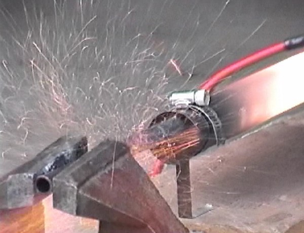 Steel tubing forming shower of sparks from DynaJet exhaust [closeup] - photo (c) 
			2003 Cottrill Cyclodyne Corp.